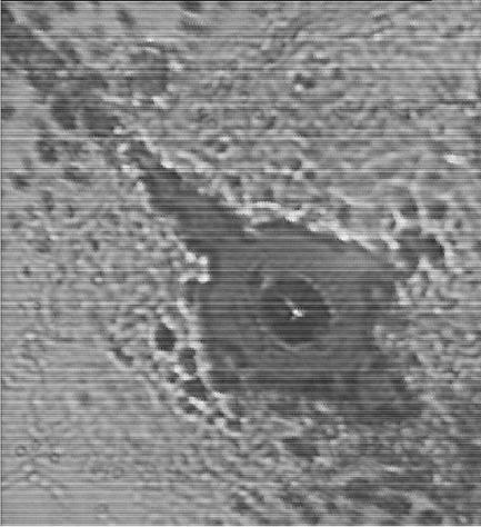 Ezek fehér közepe az intenzív forró fókusz helye. A foltot körülvev sötét pontok a kráter köré kiszórt anyagmaradványok.