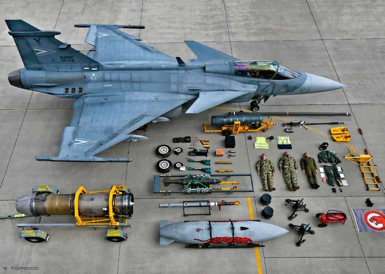 A képen felismerhető: egy Gripen vadászgép a hajtómű ledobható üzemanyagtartály bomba pótkerekek tűzoltó készülék pilótaruha + két katona a 101.