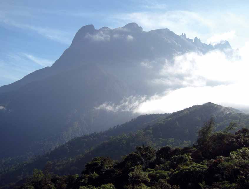 Itt-ott kilátás nyílik a szomszédos hegyoldalakra, ahol a zöld sokféle árnyalatában pompázó lombsátor felett párafelhők gomolyognak. Úgy 3200 méter magasan előbukkan a ködből a Laban Rata-menedékház.