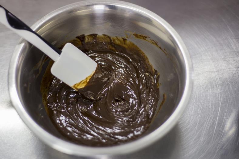 A GANACHE KÉSZÍTÉS TECHNIKÁJA: Öntsd a forró tejszín 1/3-át a felolvasztott csokoládéra és a tál közepén kezd el keverni.