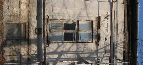 A nutázott vakolatsíkból plasztikusan emelkednek ki az ablakok feletti íves és háromszög alakú timpanonok. A nyíláskeretezést gyémántmetszéses motívumok díszítik.