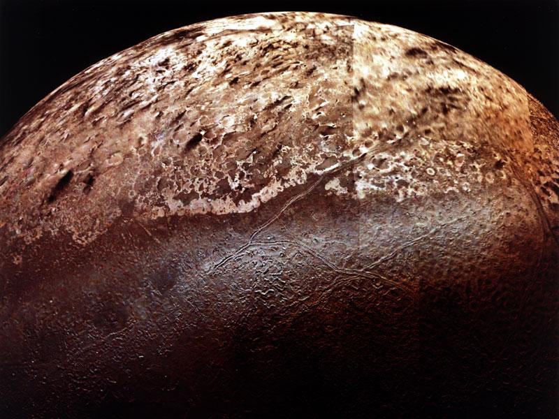 A Triton (NASA/JPL). A pályáját a többi holdéval ellenkező irányban kerüli meg, azaz retrográd mozgást végez. A pályahajlása nagy.