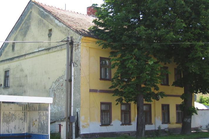 R. katolícka fara arkádami, má konvexnokonklávny parapet. Bočné fasády kostola členia veľké združené okná románskych tvarov.