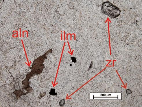 Gyakori akcesszórikus elegyrész továbbá a cirkon, valamint különféle ritkaföldfém tartalmú ásványok is megjelennek a mintákban, leggyakrabban allanit, ritkábban monacit és/vagy xenotim (2. ábra).