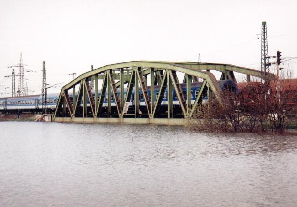 13-116. kép. Zagyva vízszintje elérte a szolnoki vasúti híd alsó élét 2000-ben. Az elhaladó személyvonat mögött látszik a híd leterhelésére beállított kővel rakott tehervonat. 13-117. kép. A Nagy-ág torkolatánál 1998-ban az áramló víz elmosta a hídpillér környezetében a talajt, a pillér megsüllyedt, ami híd lebontásához vezetett.
