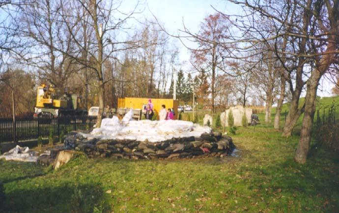 13-92. kép. A tivadari buzgár, a háttérben jobb oldalon az 1947. december 31-i gátszakadás emlékművének kövei.