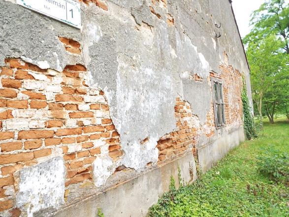 A cementrabic lábazat feletti szakaszon jelentős a nedvesség okozta vakolatkár, amelyet a nedvesség és a sók