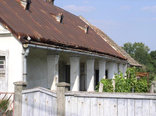 Udvar felőli homlokzatát falazott oszlopokon áll tornác alkotja.