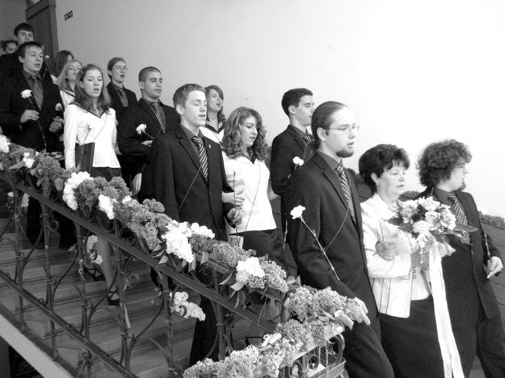Farkasné Perlaki Edit osztályfőnök és a 12. N osztály az alma mater lépcsőjén nő érkezett hozzánk, és attól kezdve a fiúkból álló dalárdánk lelkesen énekelte a te barna lányka kezdetű spanyol dalt.
