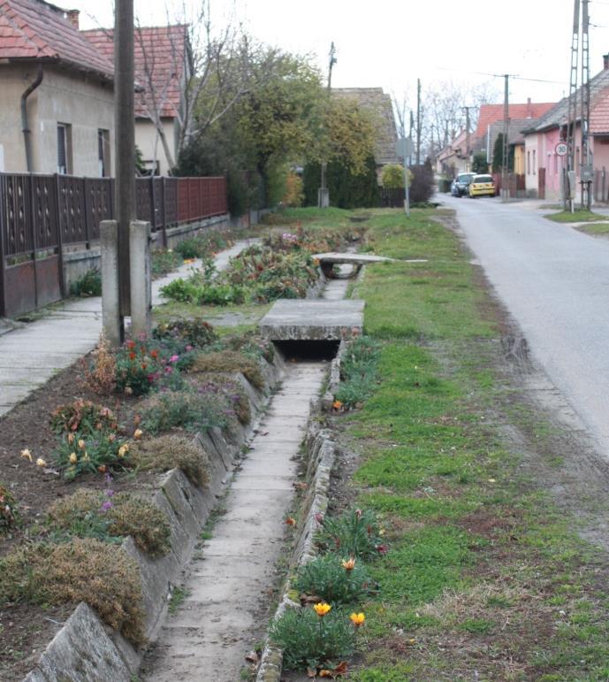 A történeti részen tágas, gyepesített árkokat látunk. A burkolt árok is barátságos tud lenni, ha környezete rendezett, ápolt.