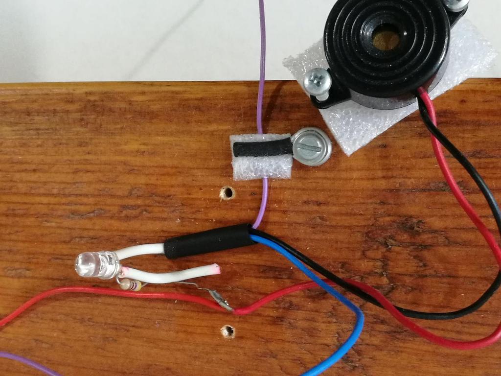 A LED és pittyegő bekötése: a lila jön a karikáról, ez a negatív, ha hozzáér a rézcső-hurokhoz LED és vele sorbakötve egy előtét ellenállás a piros jön a +5V-ról a kék az A0 analóg