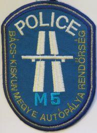 Felső részen "POLICE" felirat, alatt az autópálya nemzetközi jele, alatta "M5" felirat világoskék színnel.