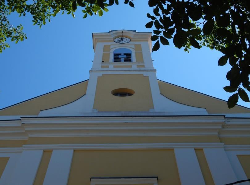 6 annál kissé zömökebb tornyát félköríves záródású ablakok és a toronysisak alsó pereménél kialakított órák tagolják.