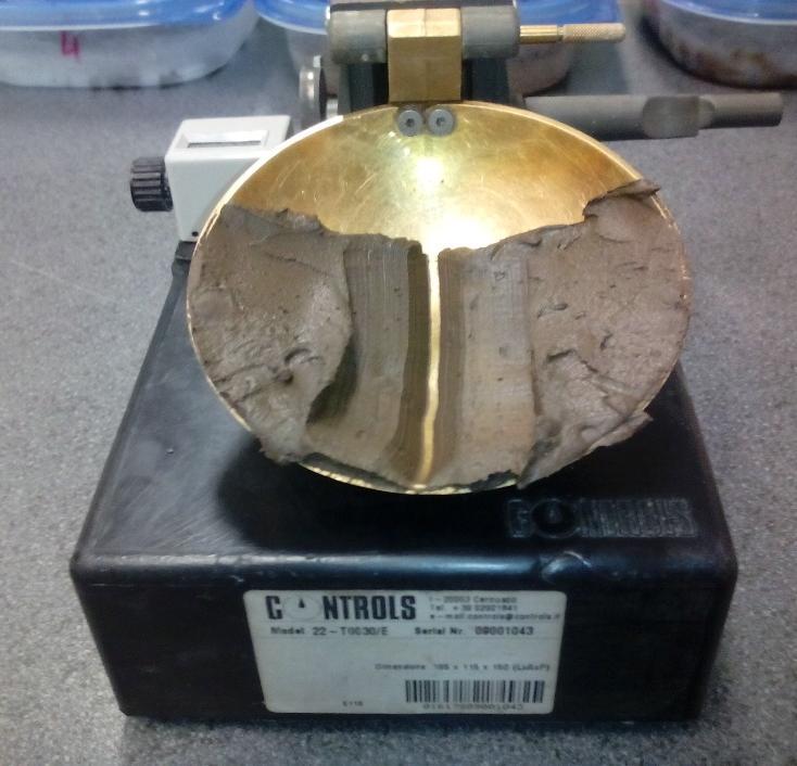 egy gumi talapzathoz ütögeti. Ennek hatására a talaj kezd összefolyni, és amikor eléri a 10 mm hosszúságot az összeért rész, meg kell határozni a talaj víztartalmát. [3] 7.