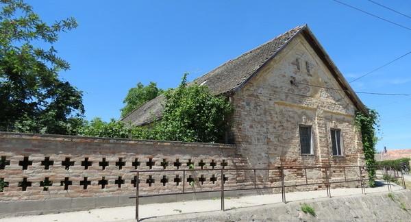 Utcára merőeleges nyeregtetős lakóépület, kisméretű, osztott ablakokkal, falsíkból kiugró sávokkal tagolt oromfallal, valamint tornácos udvari homlokzattal.