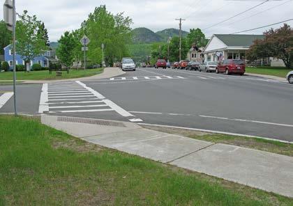 Vehicles parked on the street make it difficult for drivers to see pedestrians waiting to cross, and pedestrians may need to step out beyond the parking lane in order to see oncoming traffic.