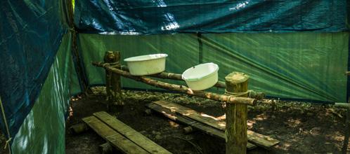 A takarás érdekében ponyvával van körbevéve. Jellemző fürdési módok: lavórban, zuhanyzsákkal, fára felkötött nagy hordóból zuhanyrendszerrel, kézikannával.
