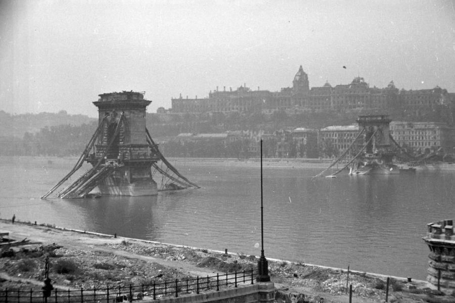 3.13. ábra: A felrobbantott Lánchíd 1945-ben [18]. 3.14. ábra: A budai nyílás kettétört pályalemeze [6]. 1947.