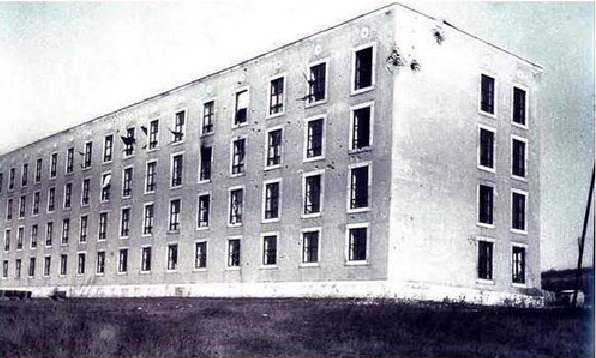 1956. november 4. A hajnali órákban a Hejőcsaba irányából az egyetemre támadó szovjet páncélos egység által tűz alá vett első diákszálló épülete.