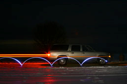 . ábra. A feladathoz tartozó kép A felvétel készítésekor az édesapja terepjárójának egyik kerekére egy világító diódát helyezett, és a 0 s expozíciós idő alatt az autó egyenletes sebességgel mozgott.