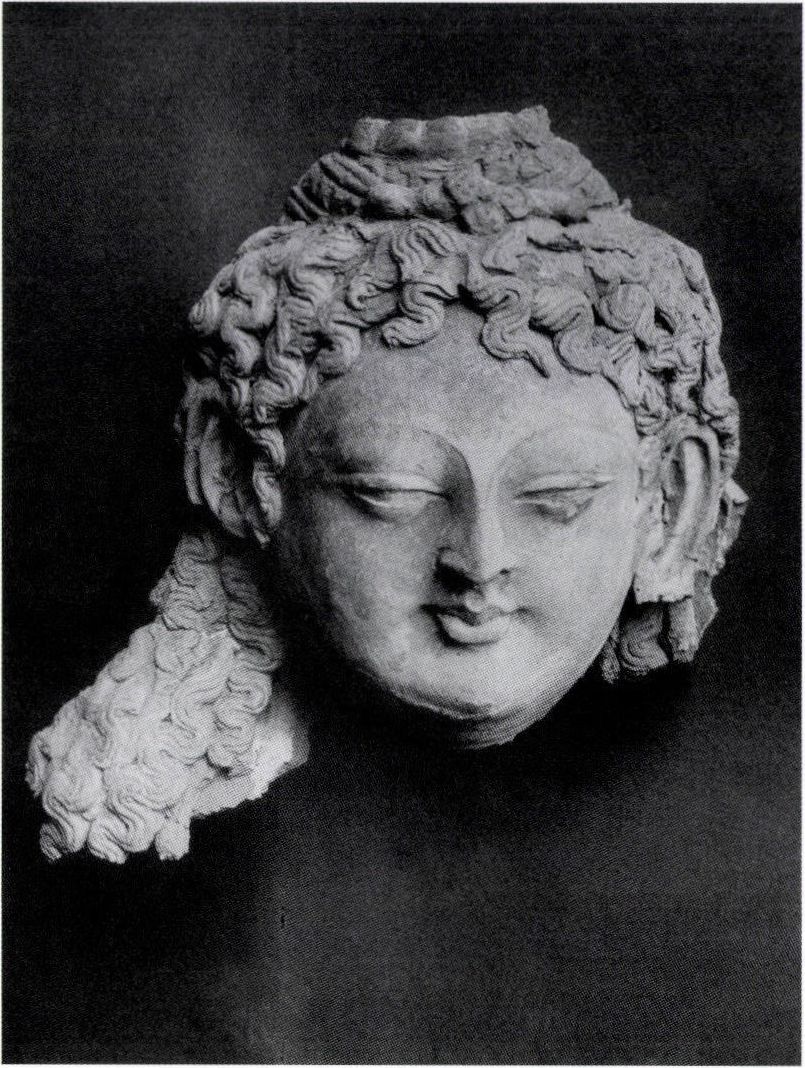 Bódhiszattm fej, Minjy-oi, 7-8. század. Ez a szobortöredék a tűzben megrongálódott XV. számú szentélyből származik, ezért eredeti festése megsemmisült.