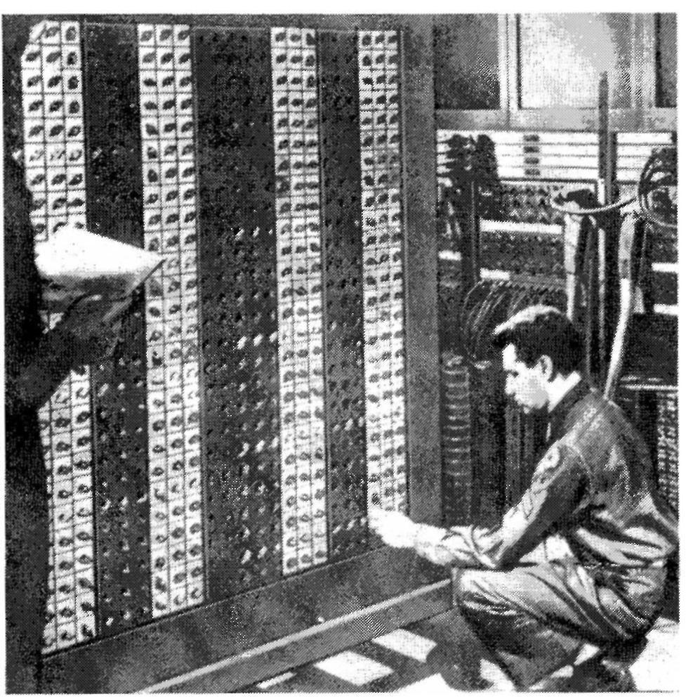 Irwin Goldstein tizedes beállítja az ENIAC kapcsolóit. Neumann János ebben az időben a Manhattan tervben, az atombomba előállításán dolgozott.