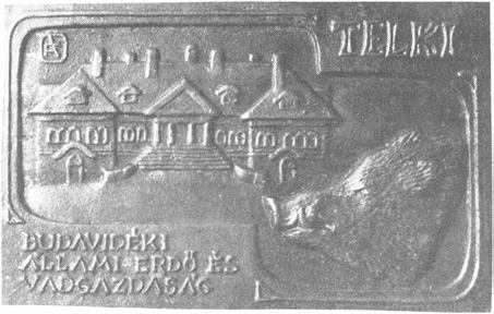 Budavidéki E V A G 69 2-701 Emlékplakett E: Bemélyített rész bal felső térfelében a Gazdaság főépületének homlokzati képe, jobb alsó részén balra néző vadkan fej Jobb felső részen díszbetűkkel: