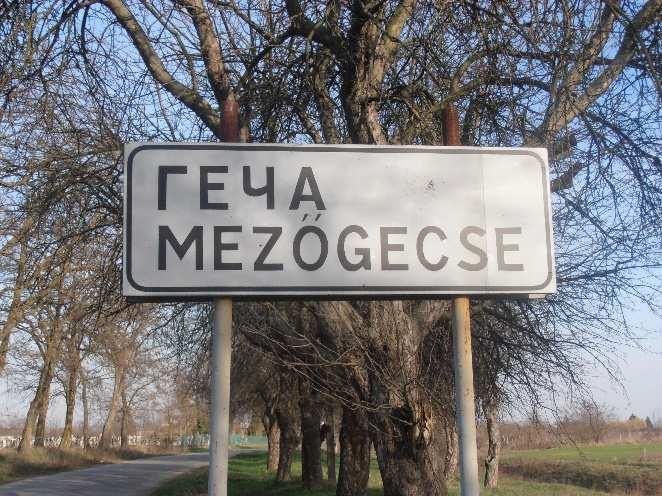 A 2012-es nyelvtörvény gyakorlati alkalmazása 195 községbe érkezőket, emellett látható a falu címere is.