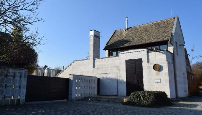 ETYEK 95 HARASZTHY PINCÉSZET A szőlősorok között vezető, bazaltkockákkal burkolt út végén egy fehér, masszív falszerű kerítés húzódik, néhol lőrésszerűen átlyukasztva,