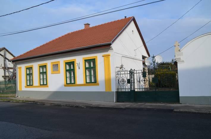 könyöklőpárkány, tagozott főpárkány, vakolatkeretben emléktábla, eredeti nyílászárók. melléképület: íves oromfal, faragott kő díszítés (váza?