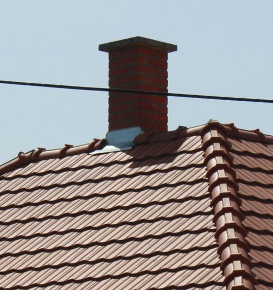 Az új szerelt kémények csillogó fémes színükkel és sűrű rögzítéseikkel ipa ri jelleget kölcsönöznek a háznak.