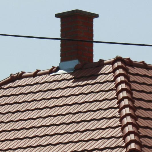 Az új szerelt kémények csillogó fémes színükkel és sűrű rögzítéseikkel ipa ri jelleget kölcsönöznek a háznak.