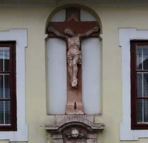 homlokzatának tengelyébe mélyített, félkörívben záródó mezőben,