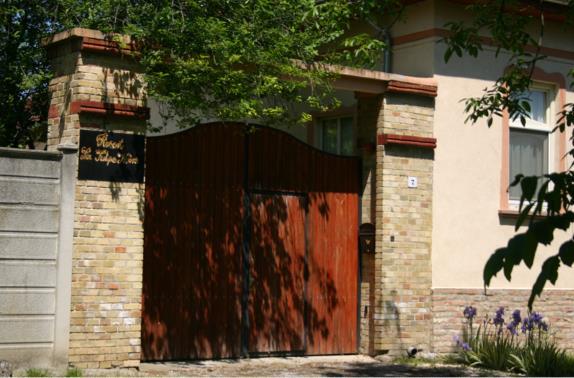 széles kaput, amin nagyméretű gépek, szénával, szalmával megrakott teherautók is be tudnak hajtani a