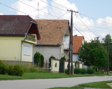 A manzárd tetős épület mellett tetőtérbeépítéses, amellett földszintes, sátortetős, majd nyeregtetős épületek