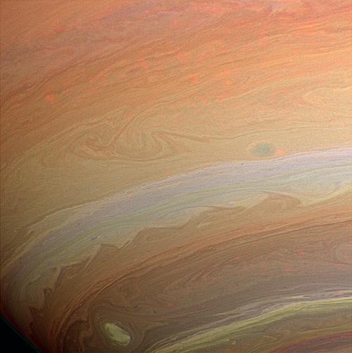A Szaturnusz kavargó felhőzónái a Cassini felvételén (NASA). A Huygens leszállóegység 2005 januárjában ért talajt a Titánon. Az elvárt óceán helyett kb. 100 méter magas dűnéket talált.