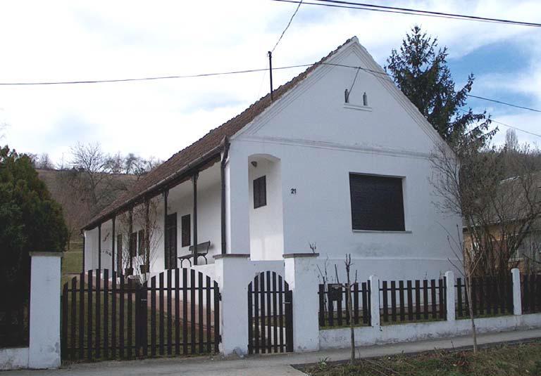 A hagyományos egytraktusos épület udvari homlokzata mellvédes, falazott oszloppilléres, szegmensíves