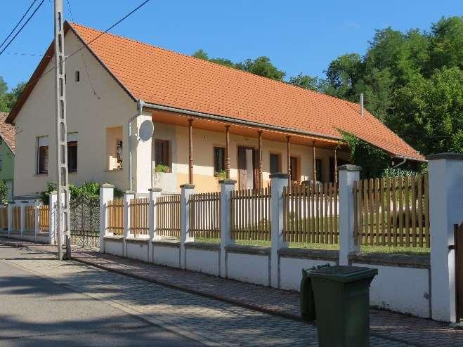 kapu beton oszlopok zöldre festése Utcára merőleges, nyeregtetős, hosszházas elrendezésű lakóépület.