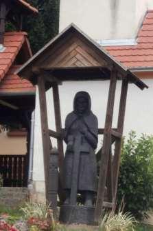 Szobrok, köztéri alkotások: Fiát sirató anya világháborús kopjafával 1992 óta fából faragott szobor áll a kápolna mellett: fiát sirató anya, és az előtte álló