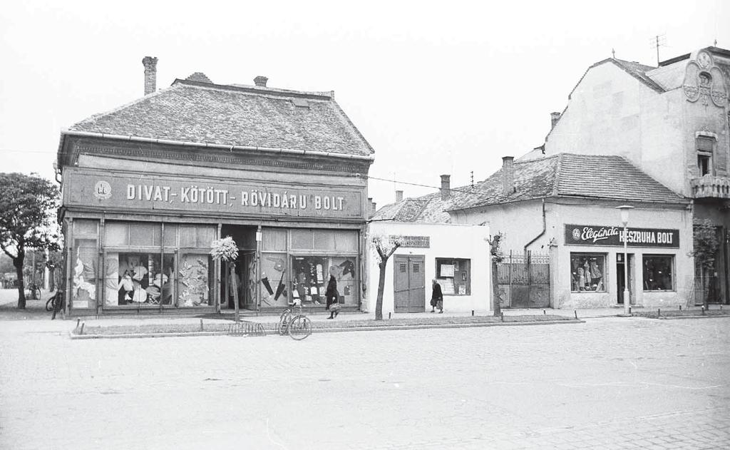 ) helyén álló kis üzletek. Divatárubolt üveges ktsz készruhabolt. 1968-ban bontották le mindhárom épületet.