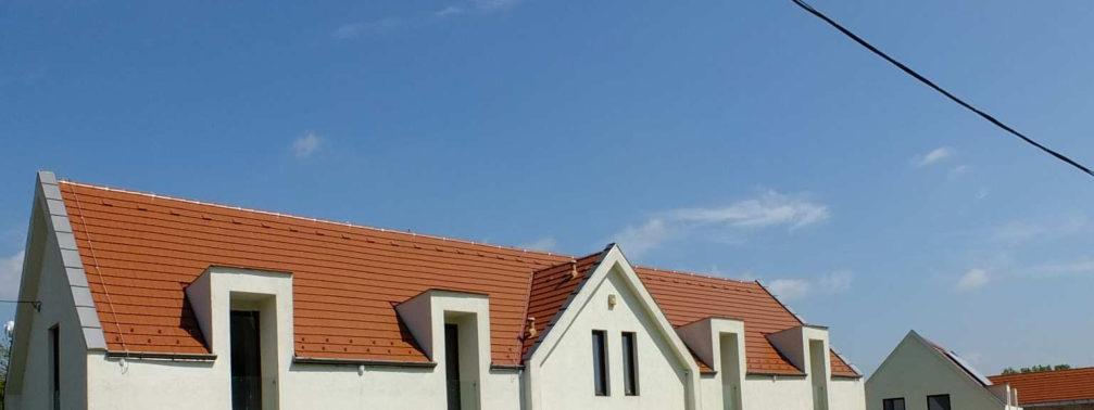 Az egyszerű tömeg vakolt felületét bontja meg a sarkon felfutó kőburkolat. A nyílászárók be- és kiugratása mozgalmassá teszi a homlokzatot.