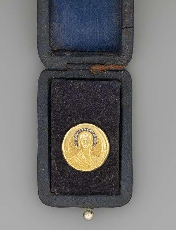 24. Kitűző tokjában Arany 580, korongforma, fiatal Szűz Mária ábrázolás, Virgo Fidelis felirattal, 15 apró