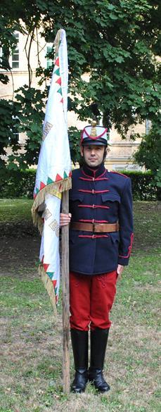 6.4. Trombitás tiszteletadása A trombita zsinórjánál fogva úgy van felakasztva a bal vállra, hogy az a jobb combra felfeküdjön.