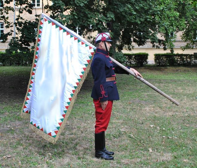 mellé rántja, bal kezével szabályszerűen megfogja a zászlórudat.