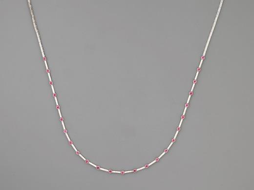 44 Nyakék Fehérarany 750, keskeny pánt, közép részén pálcika tagokon 120 apró briliáns cca. 0,80 ct (MCrSi) és 25 apró rubin ékítéssel, 12,1 g, hossz: 41 cm, rubinok kezeltek.