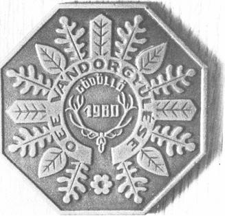 Gödöllői vándorgyűlés 86 4-109 E: Középen szarvas trófeában 1980, a szárak végei között ívesen GÖDÖLLÖ felírás. Alul nyitott, kiemelkedő szalagszerű részben bemélyítve OEE VÁNDORGYŰLÉSE felirat.