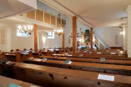 A szentélyhez kétoldalt kapcsolódó, négyzet alaprajzú mellékhajók illeszkednek. A főpárkány fölött timpanon látható. A hajó és a szentély is síkmennyezetes.