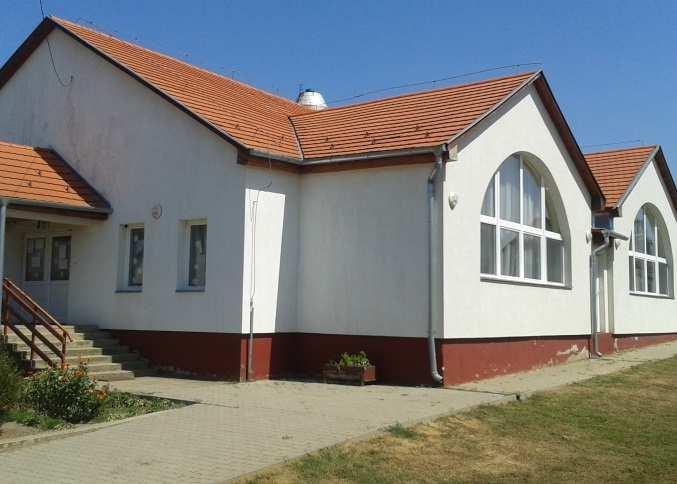 Szintszámban, építészeti megjelenésben a két templom funkciójánál és szakrális építészeti jellegénél fogva erősíti a központi hely szerepét.