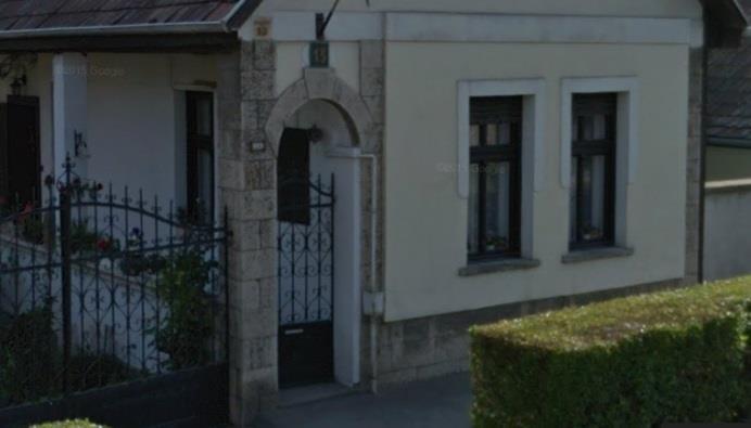 A bejárati kapuoszlopos, íves záródású nyílásában díszes vaskapu látható. A kapuoszlop és a nyílás kőkeretes.