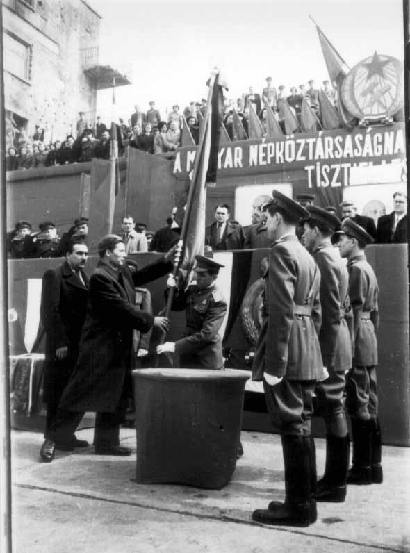 A csapatzászló átadásának-átvételének ünnepélyes mozzanata (1952) csapatzászlót kapott. A csapatzászlót a Kismotor- és Gépgyár dolgozói adományozták a Petőfi Tűz oltó Tisztképző Iskola részére.